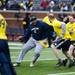 Blue Team player Gilvanni Johnson attempts to get by Maize Team players during the alumni spring flag football game on Saturday, April 13. AnnArbor.com I Daniel Brenner